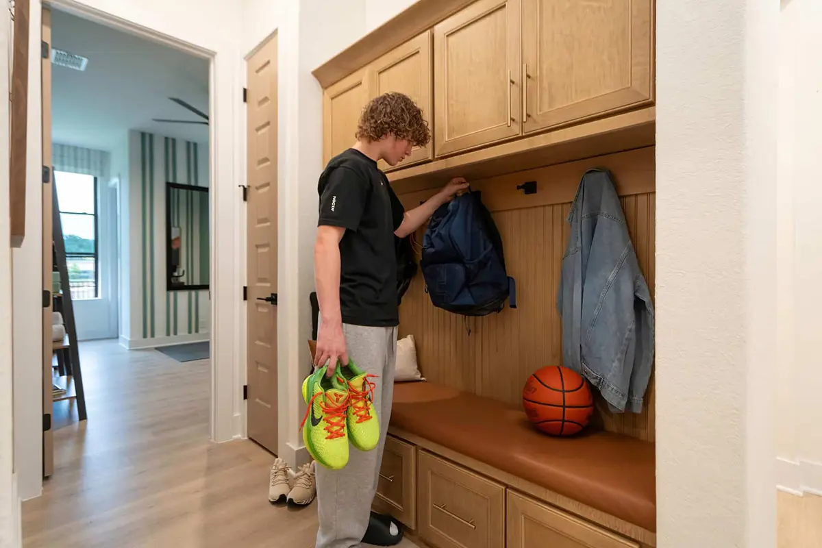 Teen hanging up backpack
