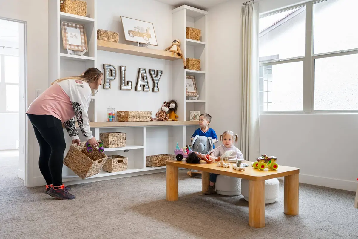 mother cleaning room with her 2 young children