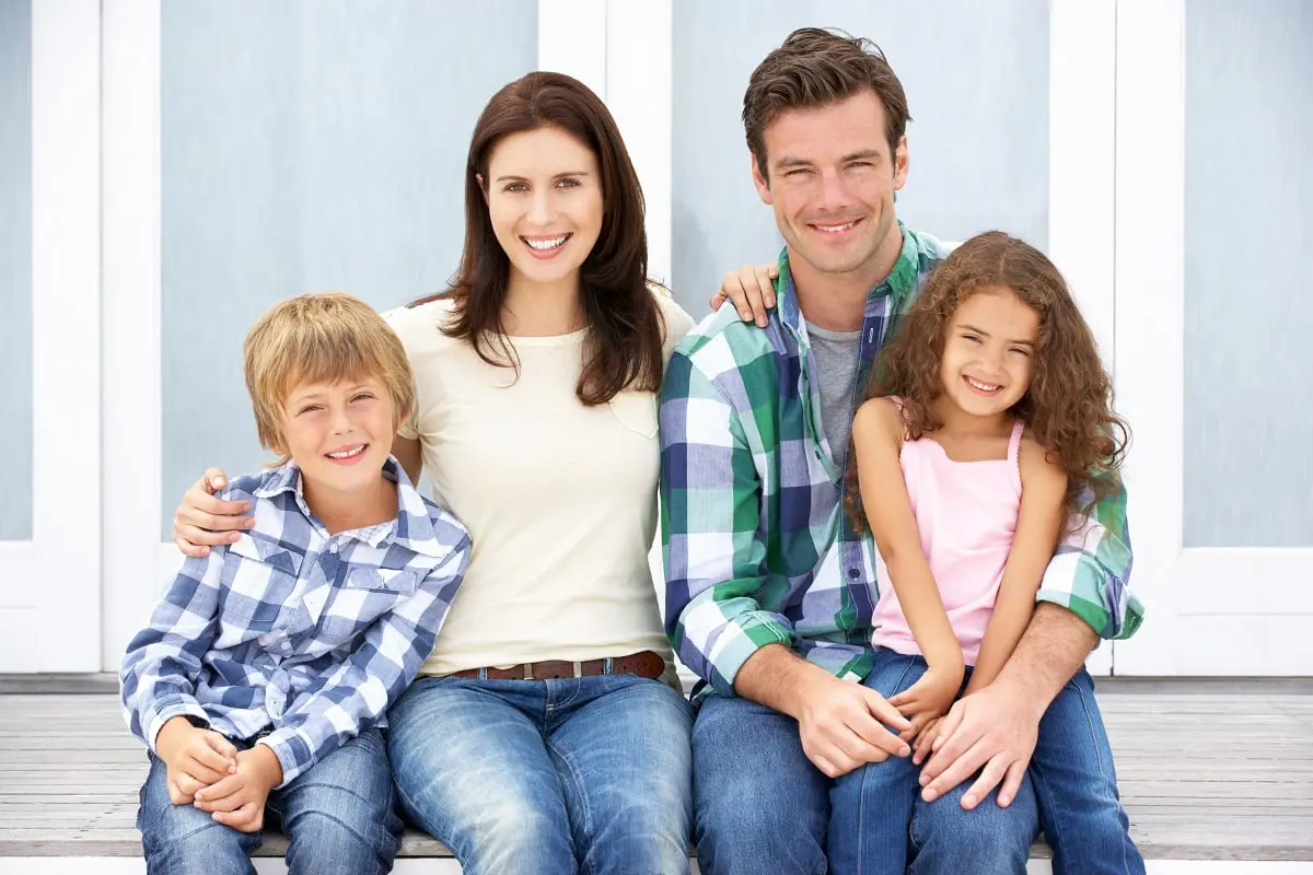 Happy family in front of home