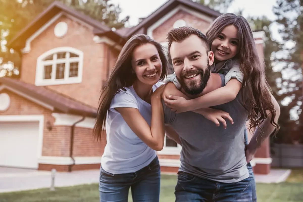 Happy family in front of home