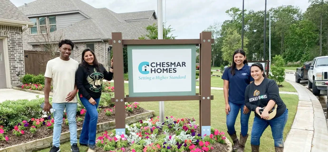 Employees standing in front of Chesmar Homes sign