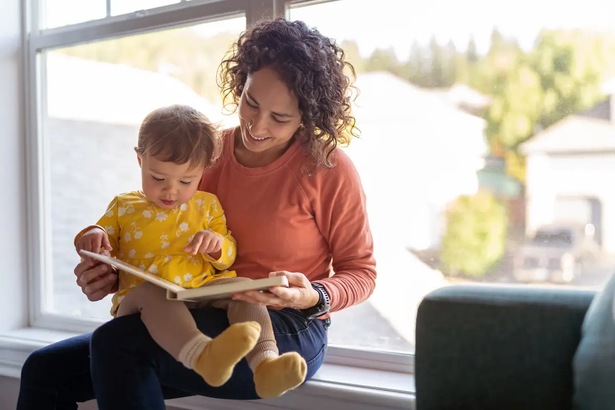 Woman reading book with child